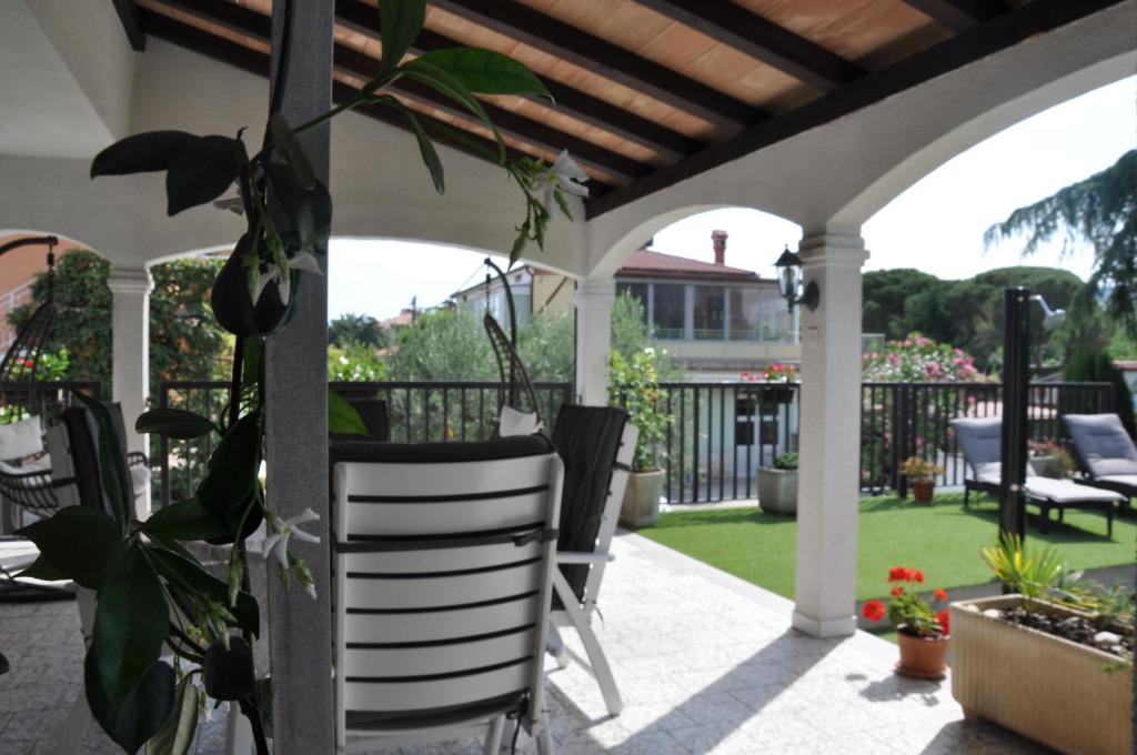 un patio extérieur avec des chaises et une pergola dans l'établissement Apartmaji Štamcar, à Izola