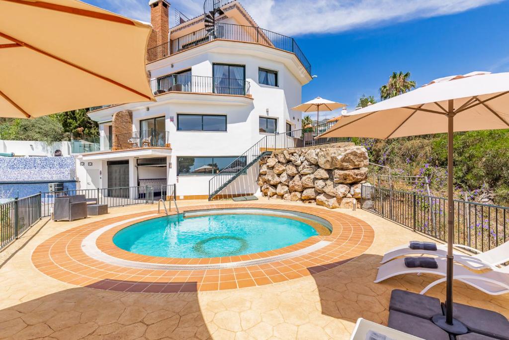 eine Villa mit einem Pool vor einem Haus in der Unterkunft Tranquil 2 bed villa with private pool + sea view! in Benalmádena