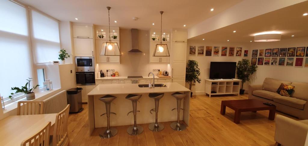 een keuken en een woonkamer met een wastafel en een bank bij Luxury 2 bed/bath apartment next to Hyde Park in Londen