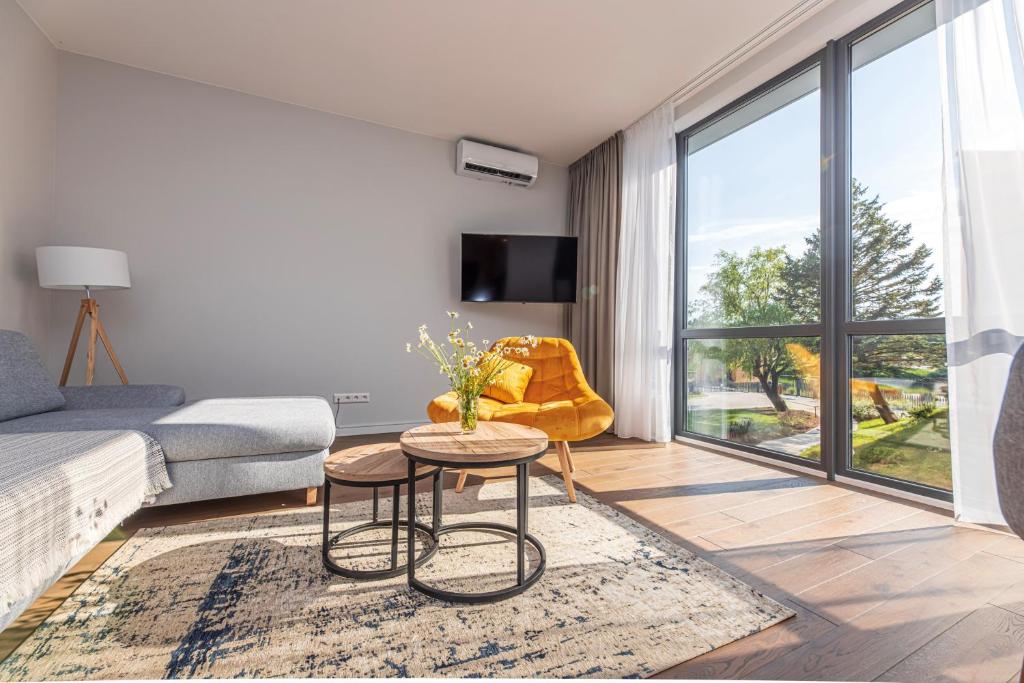 a living room with a couch and a table at Sunset Apartment at Sventosios Vartai in Palanga