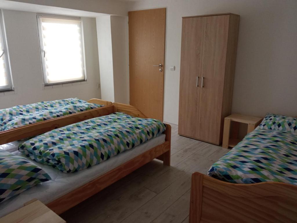 Cette chambre comprend 2 lits et une armoire. dans l'établissement Apartmán Hulín, Chrášťany, à Hulín
