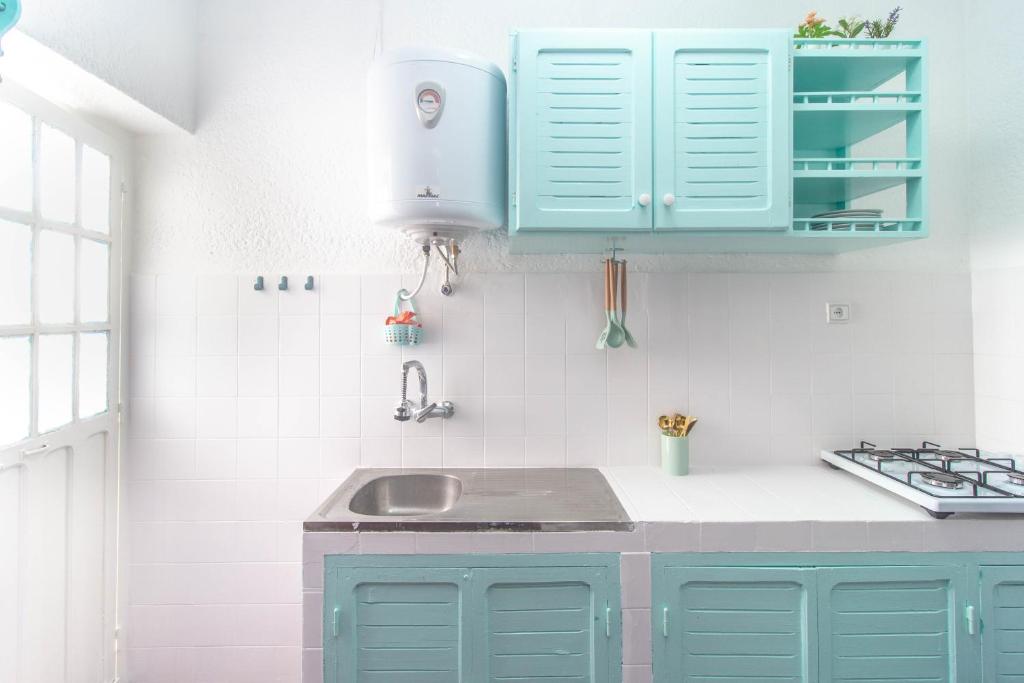 a kitchen with blue cabinets and a sink at Appartement Familial au Centre Miramar in Martil
