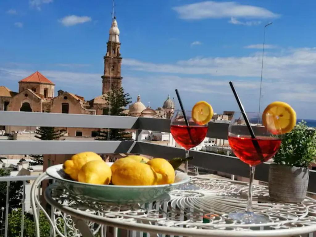 - une table avec un bol de citrons et 2 verres de vin dans l'établissement Casa Levante, à Monopoli