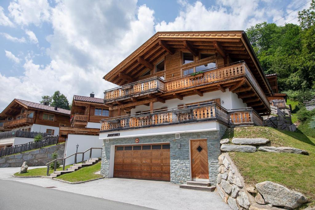 a large wooden house with a garage at Grünerstein Chalet Jungbrunnen in Bramberg am Wildkogel