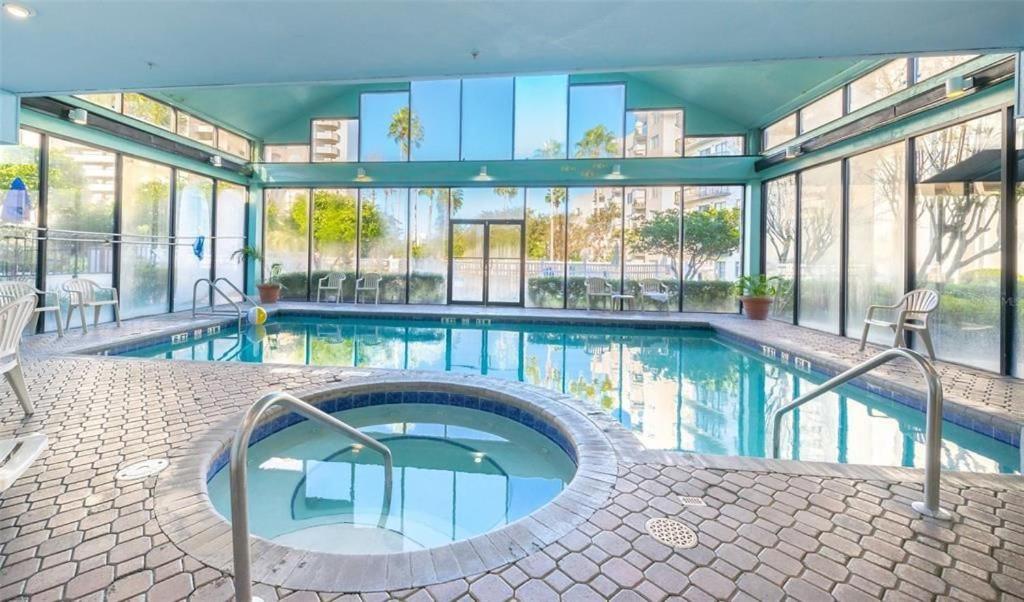 een groot zwembad met een groot gebouw met ramen bij Universal Family Fun Perfectly Located + amenities in Orlando