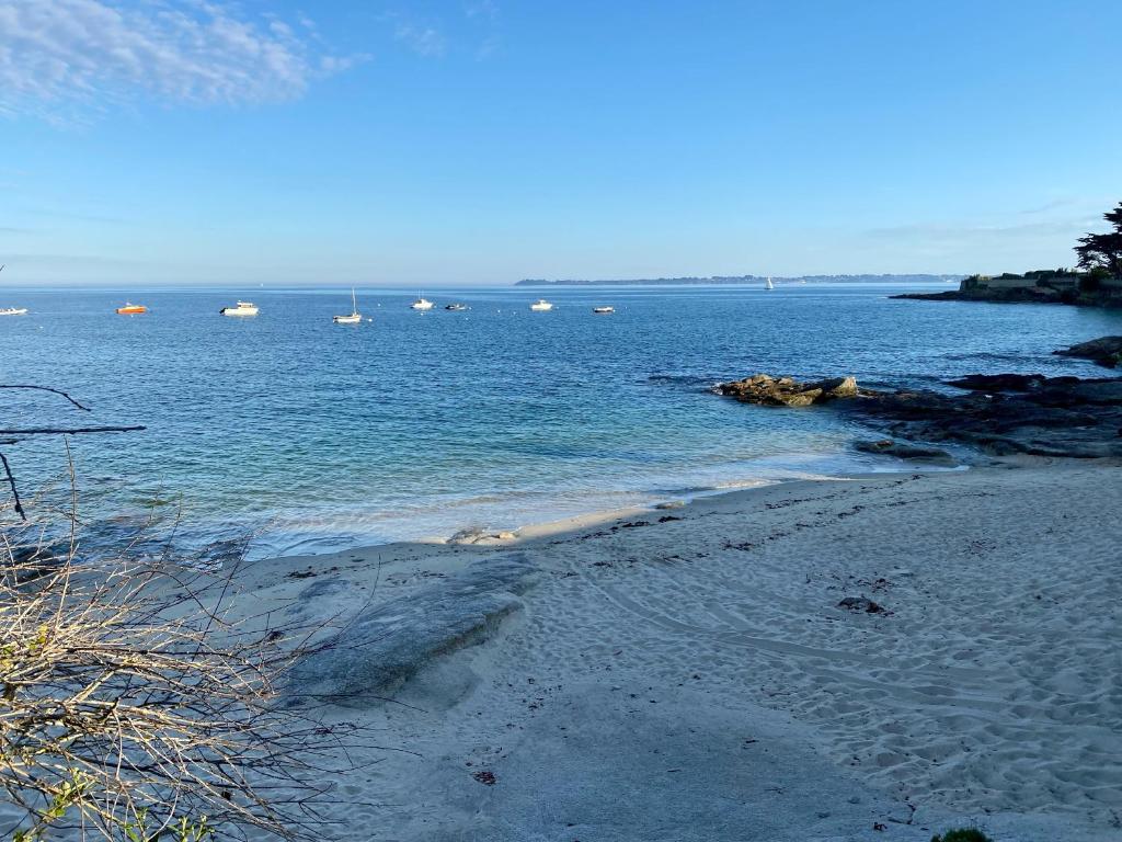 une plage de sable avec des bateaux dans l'eau dans l'établissement Casa Nomad - appartement cozy les pieds dans l'eau, à Ploemeur