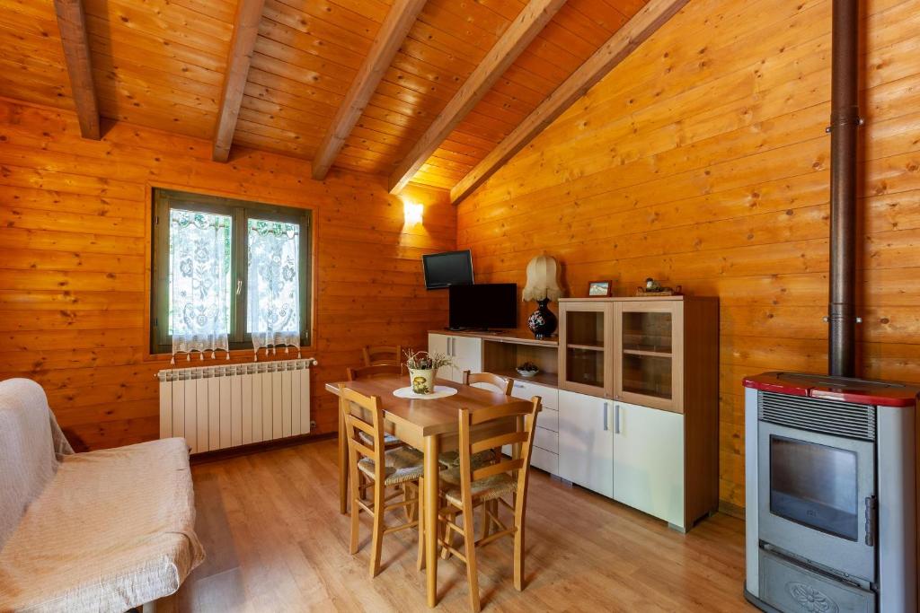 een kamer met een tafel en een keuken in een huisje bij Villaggio Anemone Chalet Scoiattolo in Capanne di Sillano