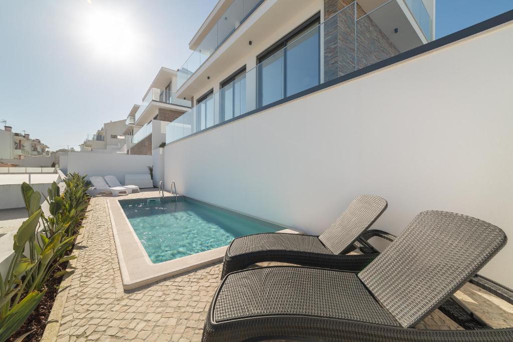 a patio with two chairs and a swimming pool at Casa do Sol - By SCH in Salir de Porto