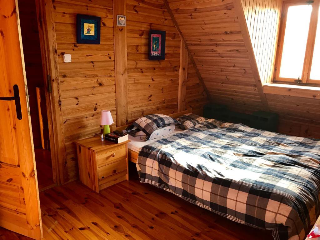 a bedroom with a bed in a log cabin at Villa Hortensja in Białogóra