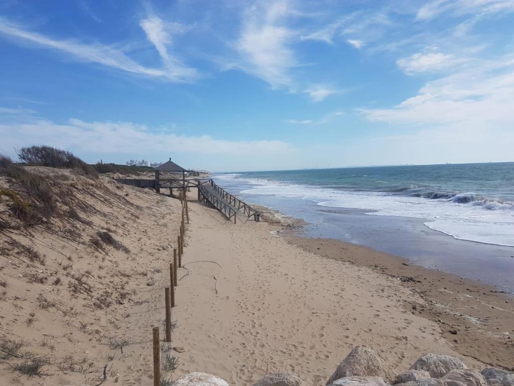 piaszczysta plaża z płotem i oceanem w obiekcie La Costilla centro y playa w mieście Rota