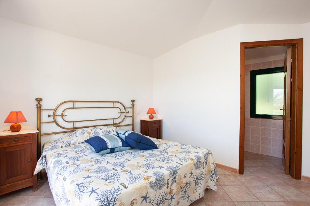 una camera con un letto e un piumone blu e bianco di Gamma 1 a Orosei
