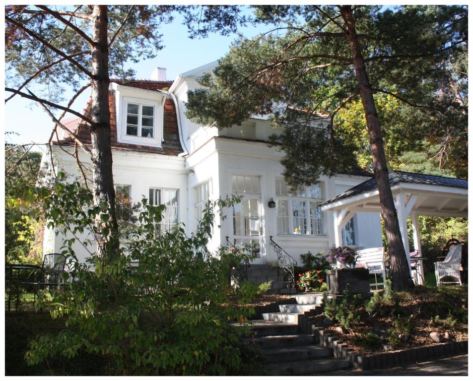 una casa blanca con árboles delante de ella en Willa Ludwinia en Gdynia