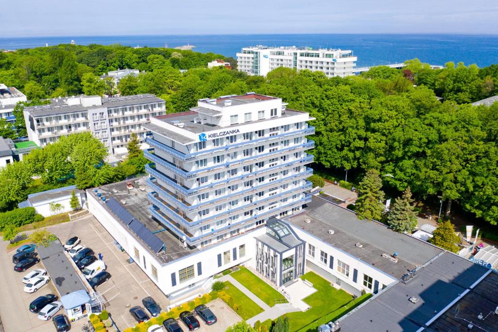 widok na duży biały budynek z parkingiem w obiekcie Kielczanka w Kołobrzegu