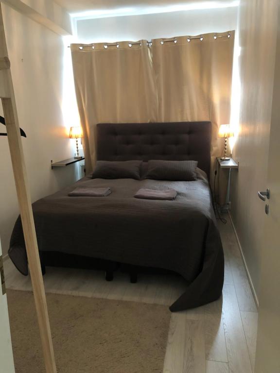 łóżko w sypialni z dwoma lampami na podłodze w obiekcie Citynest w mieście Rovaniemi
