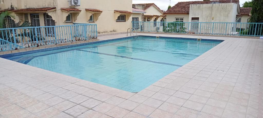 una piscina de agua azul frente a un edificio en Lyneks Cosy Apartment en Mombasa