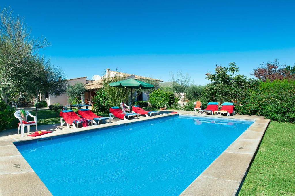- une piscine avec des chaises et des parasols dans la cour dans l'établissement Villa Garriguer by Villa Plus, à El Port