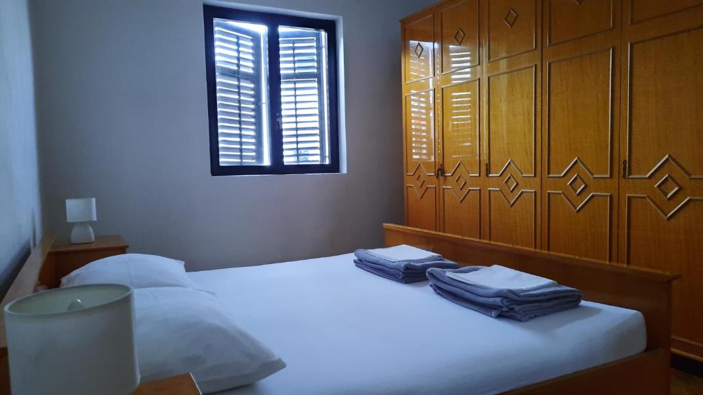 a bedroom with a bed with two blue towels on it at Vlatković in Senj