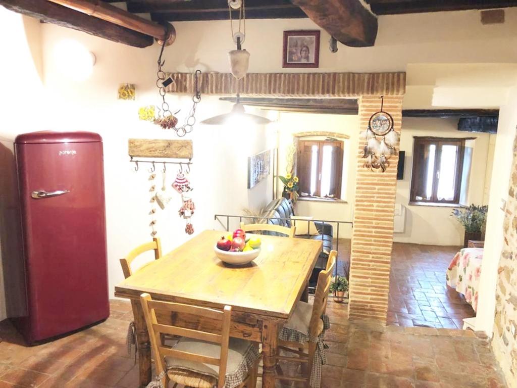 una cucina con tavolo in legno e ciotola di frutta di Il Bugigattolo a Castagneto Carducci