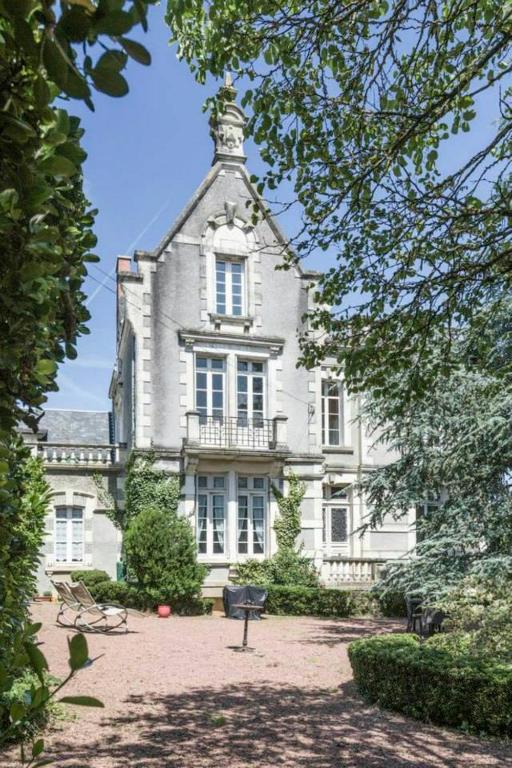 un grand bâtiment blanc avec une tour au sommet dans l'établissement Holiday home La Brijopa, à Bazoges-en-Pareds