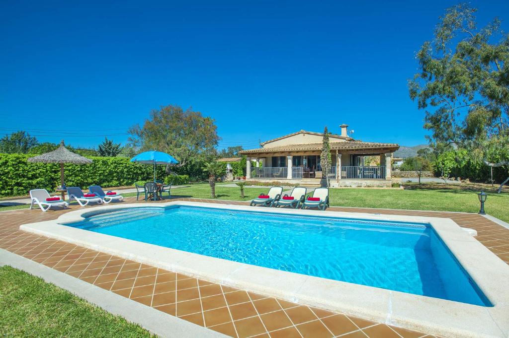 - une piscine avec des chaises et une maison dans l'établissement Villa Monserrat by Villa Plus, à El Port