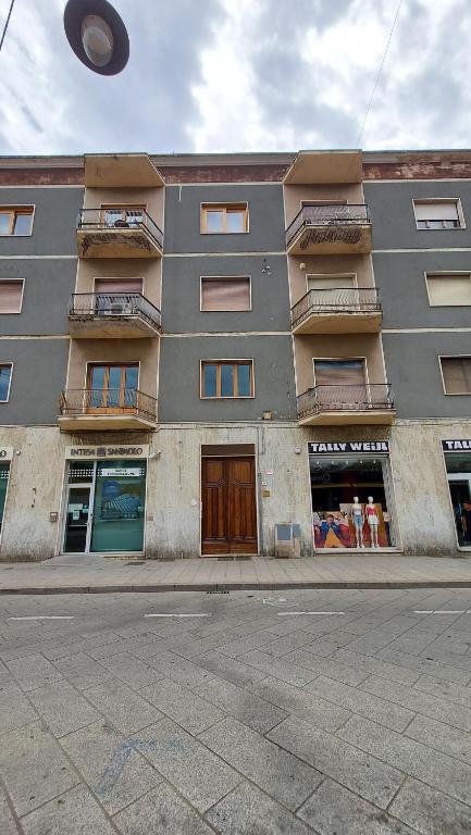 un edificio alto al lado de una calle en B&B Sa Cannacca, en Olbia