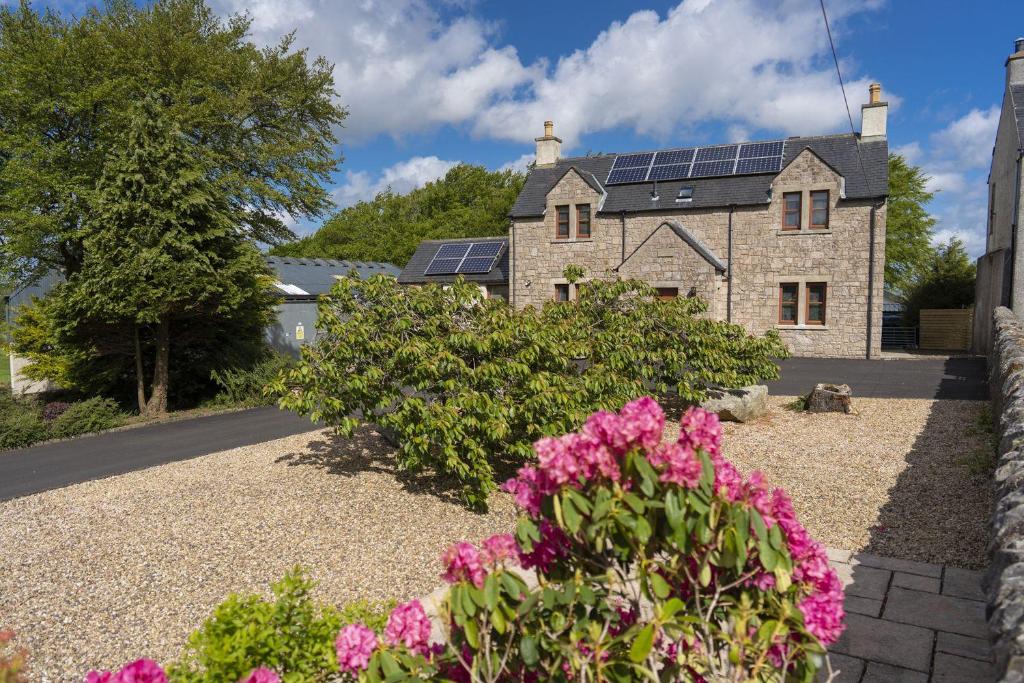 une maison avec des panneaux solaires sur le toit dans l'établissement Melville Lodge, à Cumbernauld