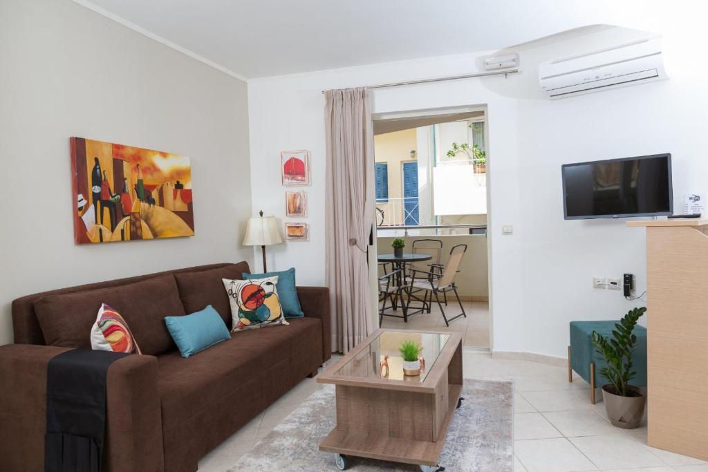 a living room with a brown couch and a table at Anemone City Center Apartment in Heraklio