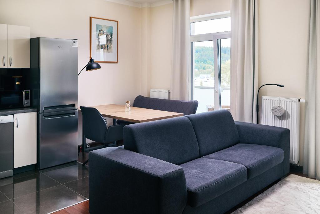 a living room with a couch and a table at Apartman Residence Moser 1504 in Karlovy Vary