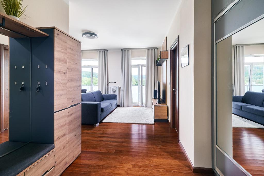 a living room with blue couches and a large mirror at Apartman Residence Moser 1504 in Karlovy Vary