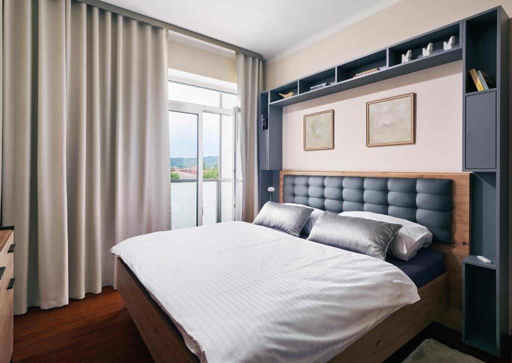 a bedroom with a large bed and a window at Apartman Residence Moser 1504 in Karlovy Vary