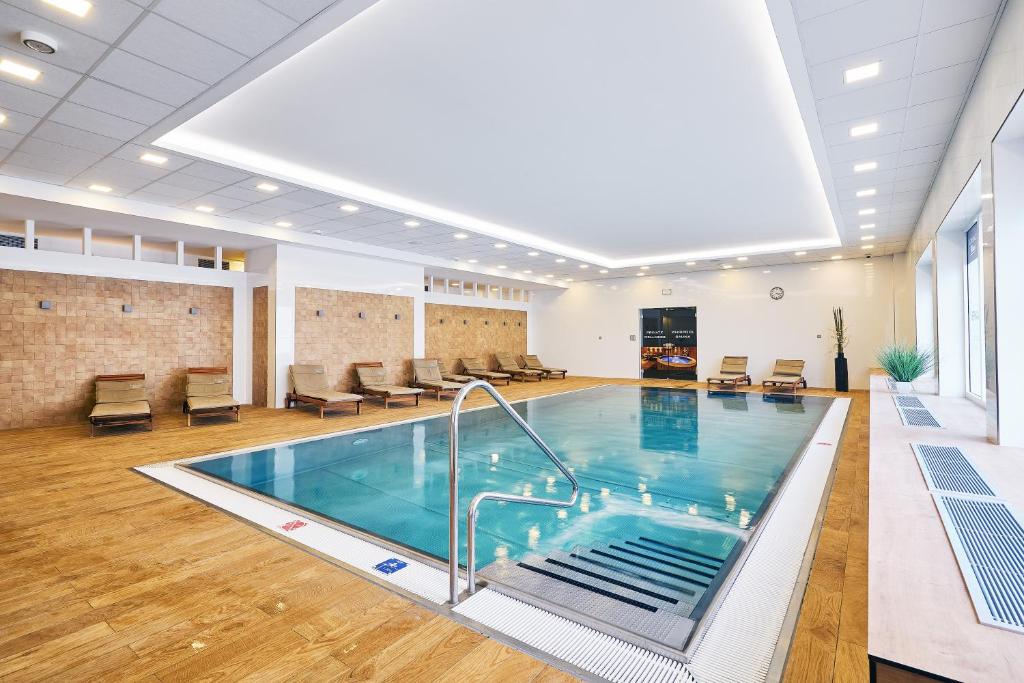 a pool in a large room with a large ceiling at Apartman Residence Moser in Karlovy Vary