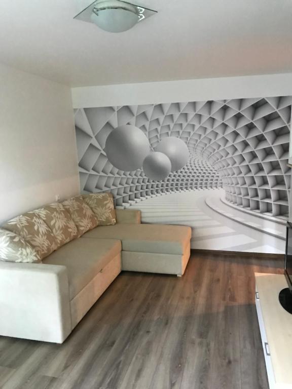uma sala de estar com um sofá e uma parede em Reiu Apartment em Reiu