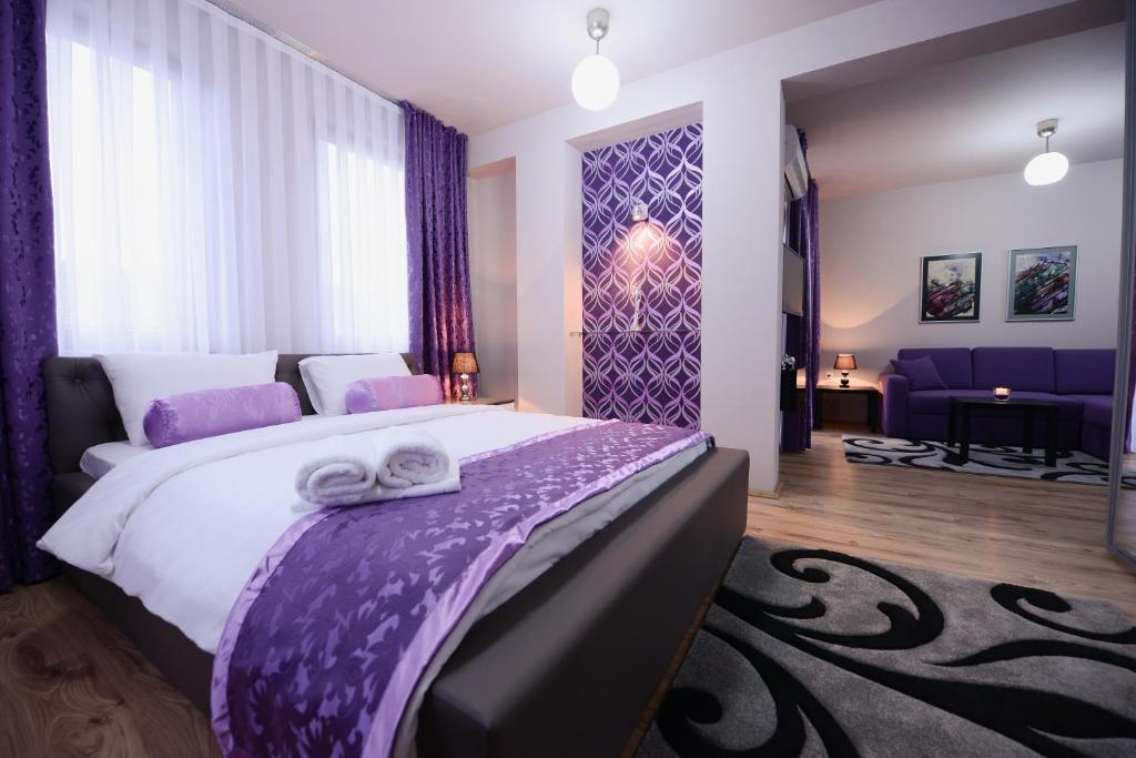 a bedroom with a large bed with towels on it at Millenium Travel Apartments in Bitola