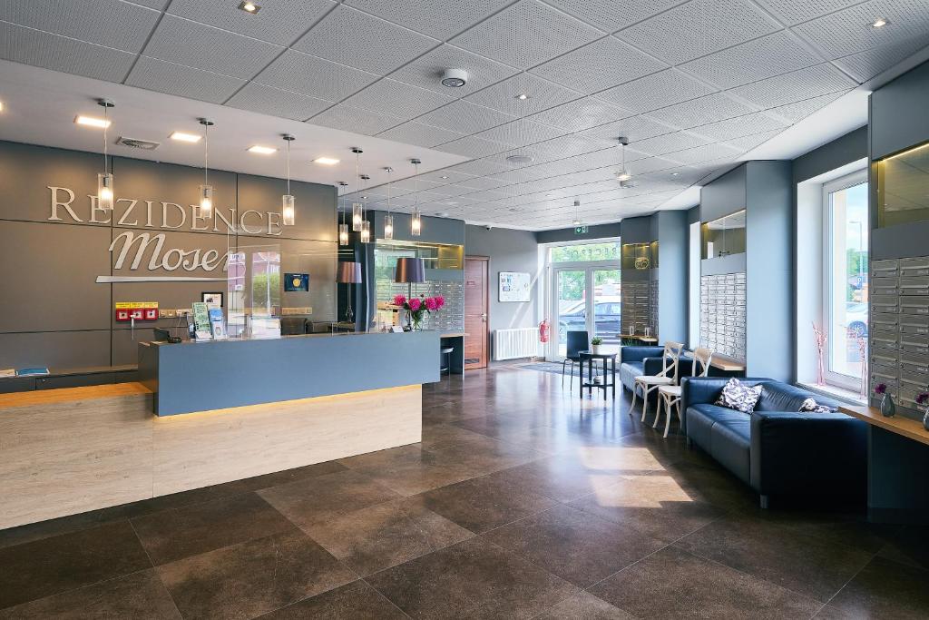 a restaurant lobby with a counter and chairs at Apartman Residence Moser 1504 in Karlovy Vary