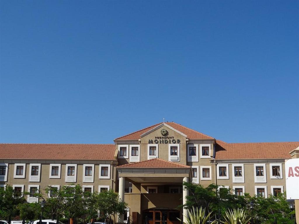 un grand bâtiment avec un panneau devant lui dans l'établissement Peermont Mondior Hotel, à Gaborone