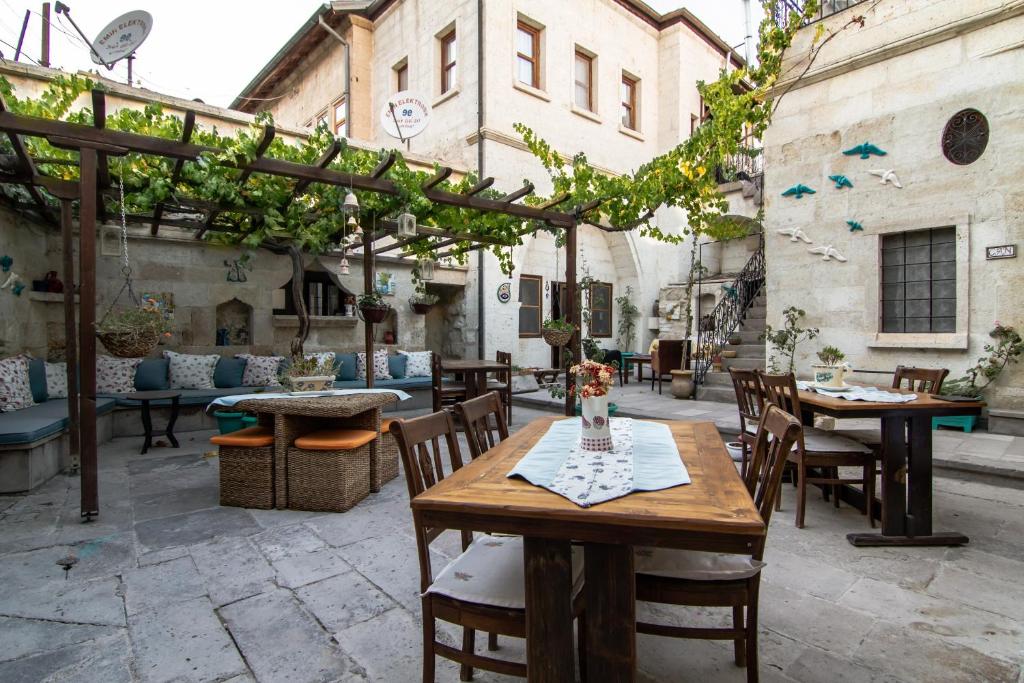 eine Außenterrasse mit Tischen, Stühlen und einer Pergola in der Unterkunft Urgup Konak Hotel in Ürgüp