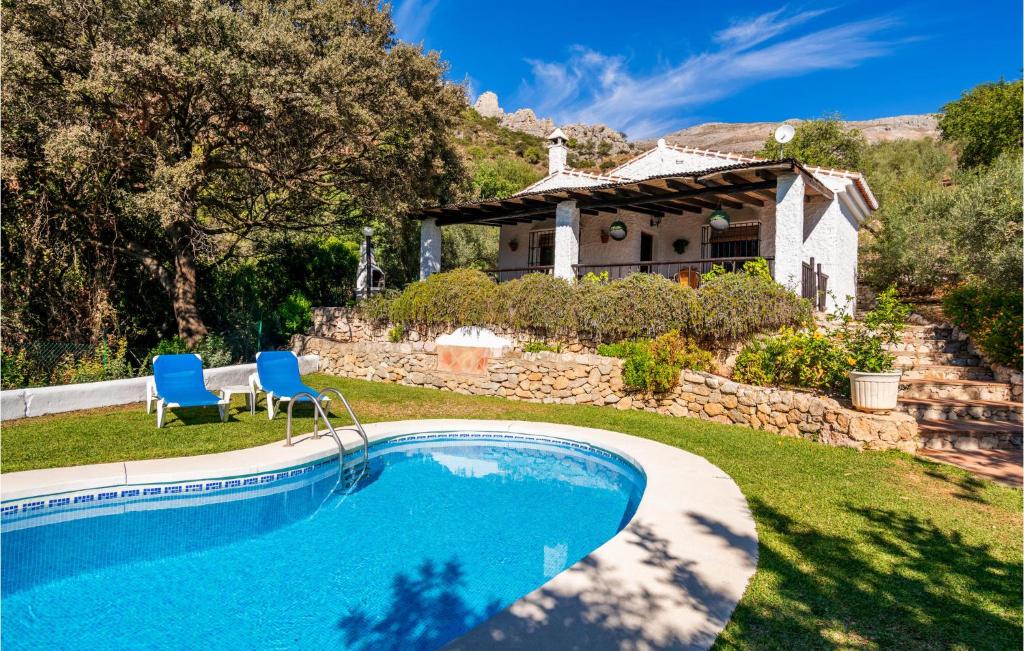 een zwembad in een tuin met een huis bij 2 Bedroom Beautiful Home In Alora in Alora