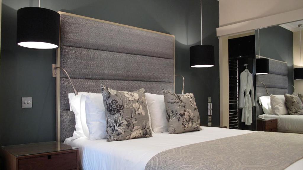 a bedroom with a large white bed with pillows at Boutique Barclay House London townhouse - West London, Kensington, Chelsea, Fulham in London
