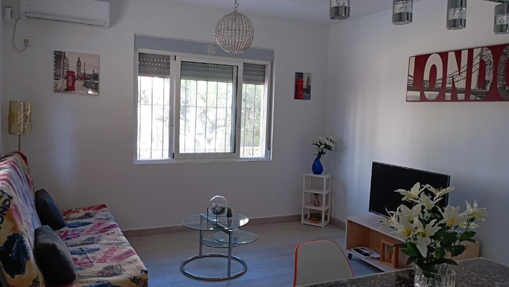 - un salon avec un canapé et une télévision dans l'établissement Apartamento completo, mascotas aceptadas, à Arenales del Sol