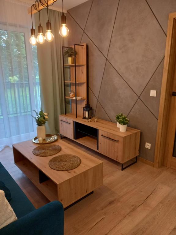 - un salon avec deux tables et un mur dans l'établissement APARTAMENT PRESTIGE OŚWIĘCIM, à Oświęcim