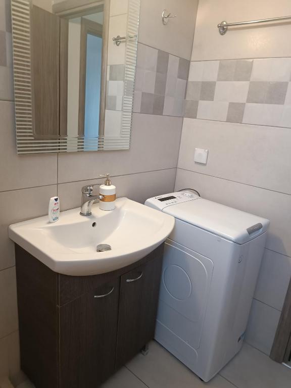 ein Badezimmer mit Waschbecken, Toilette und Spiegel in der Unterkunft Buganvilla Sea View apts in Agia Pelagia