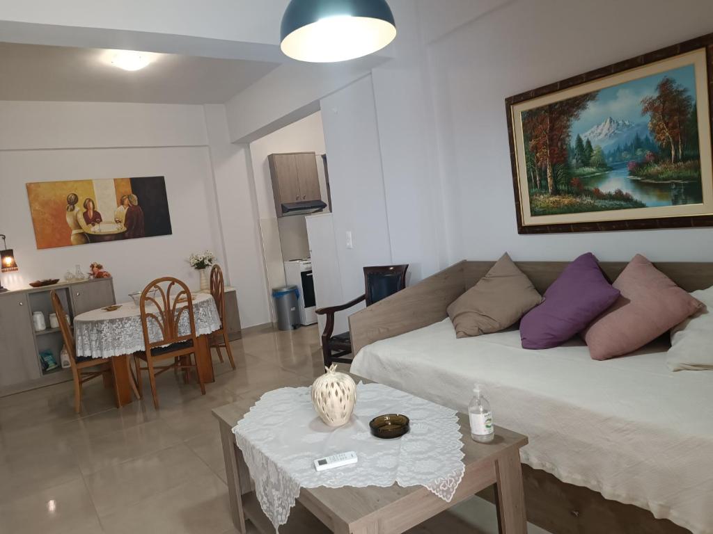 ein Wohnzimmer mit einer Couch und einem Tisch in der Unterkunft Buganvilla Sea View apts in Agia Pelagia