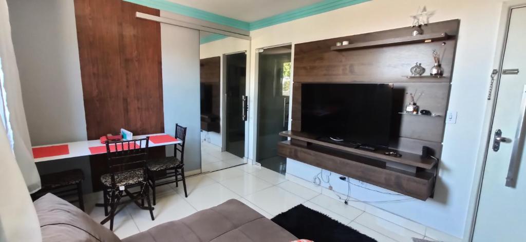 a living room with a couch and a table and a television at Apartamento Mobiliado, Parque Atheneu. in Goiânia