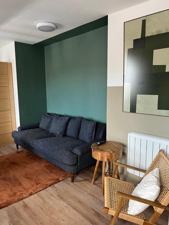 a living room with a blue couch and a table at Peak Willow Apartments in Leek