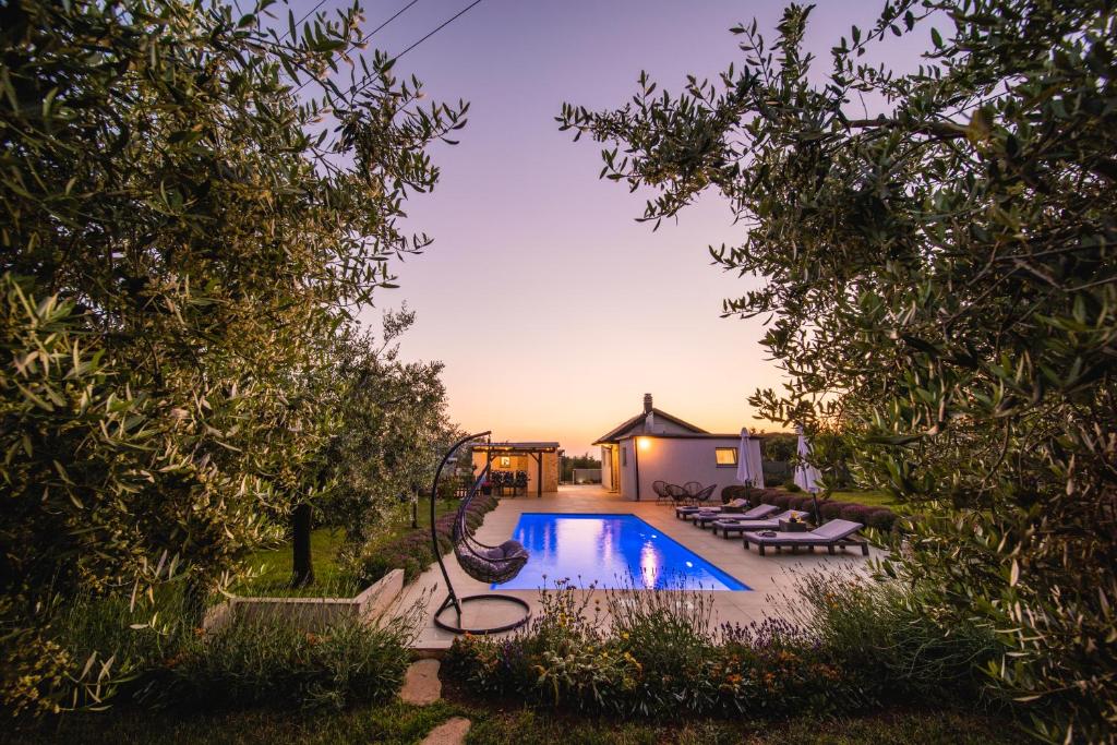 een zwembad met ligstoelen en een huis bij Leonardo House in Novigrad Istria