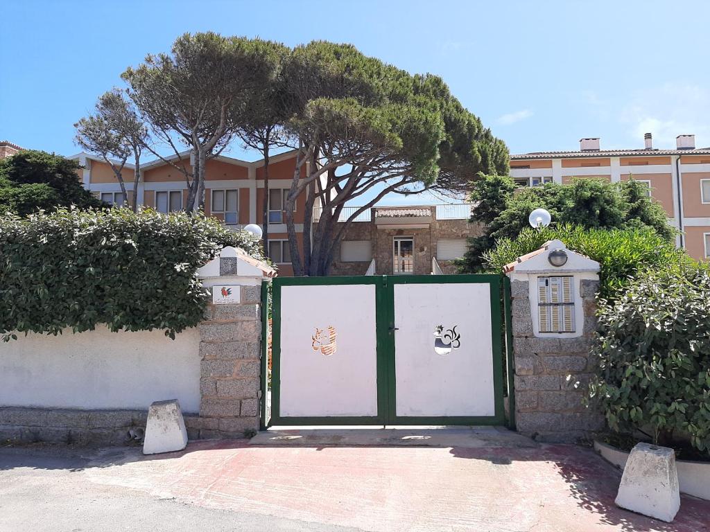 a green and white gate in front of a building at Overlooking the sea Santa Teresa Gallura in Santa Teresa Gallura