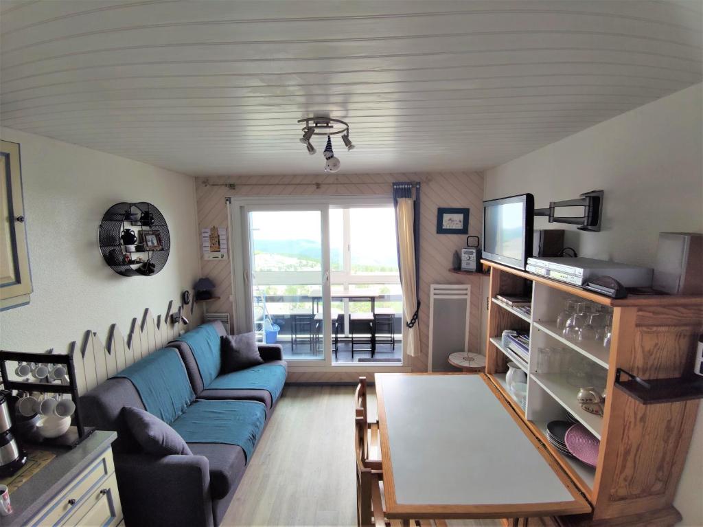 een woonkamer met een blauwe bank en een tafel bij studio Batlou ménage inclus in Arette