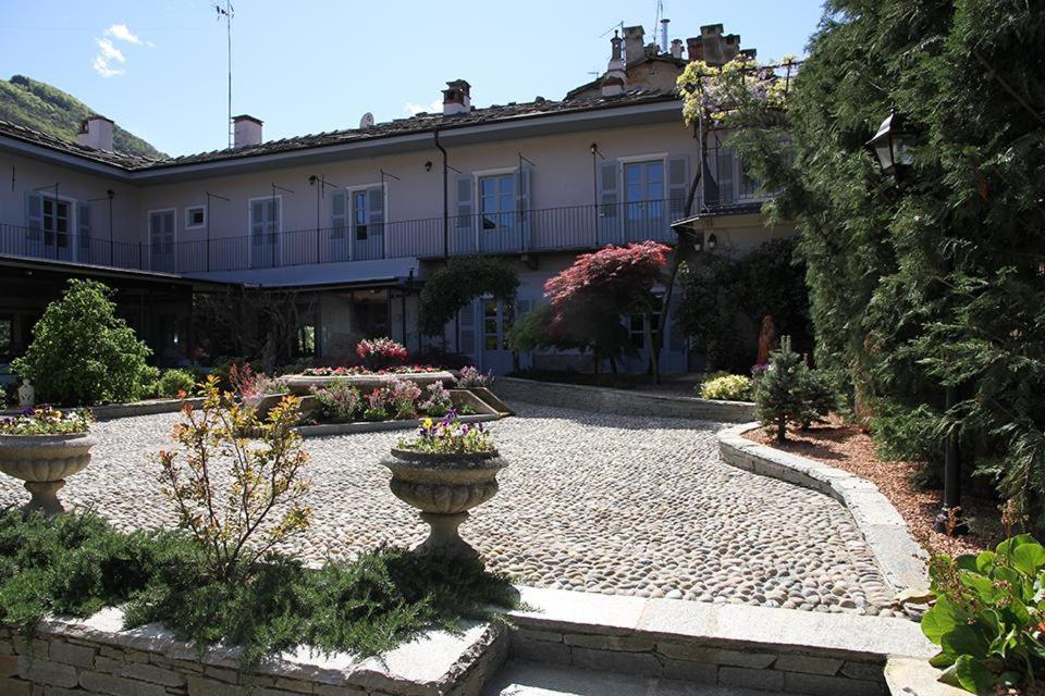 einen Innenhof mit zwei Urnen vor einem Gebäude in der Unterkunft Maison Flipot in Torre Pellice