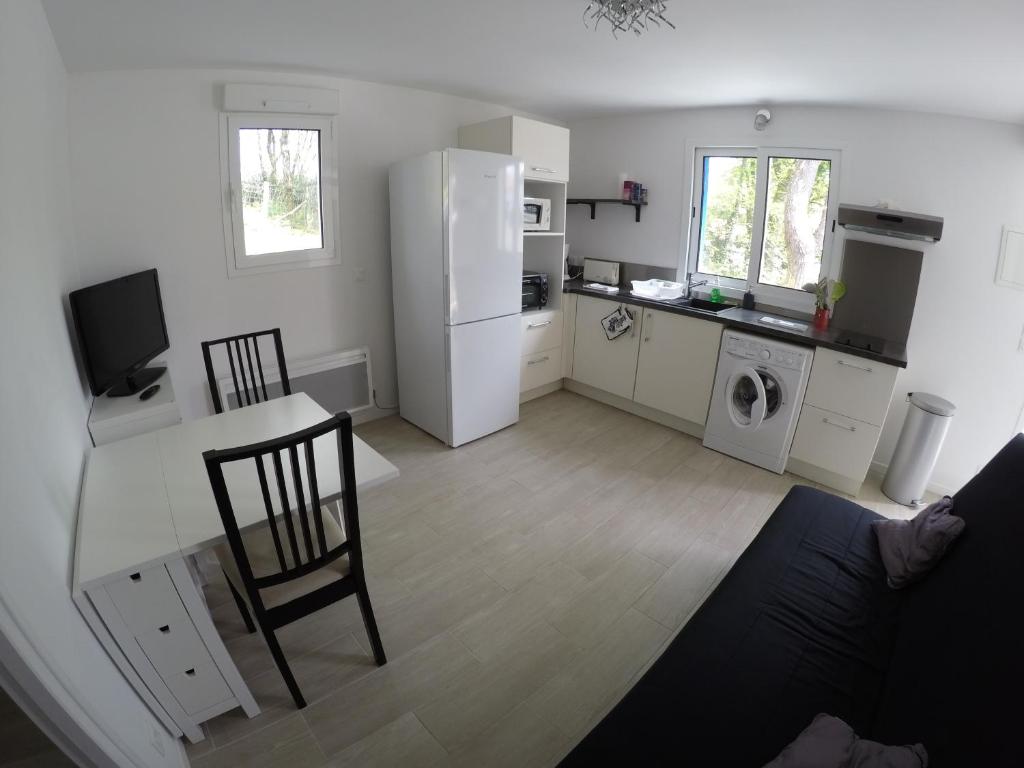 Il dispose d'une cuisine et d'un salon avec une table et un réfrigérateur. dans l'établissement Beau T2 neuf au calme entre mer et montagne, à Bassussarry