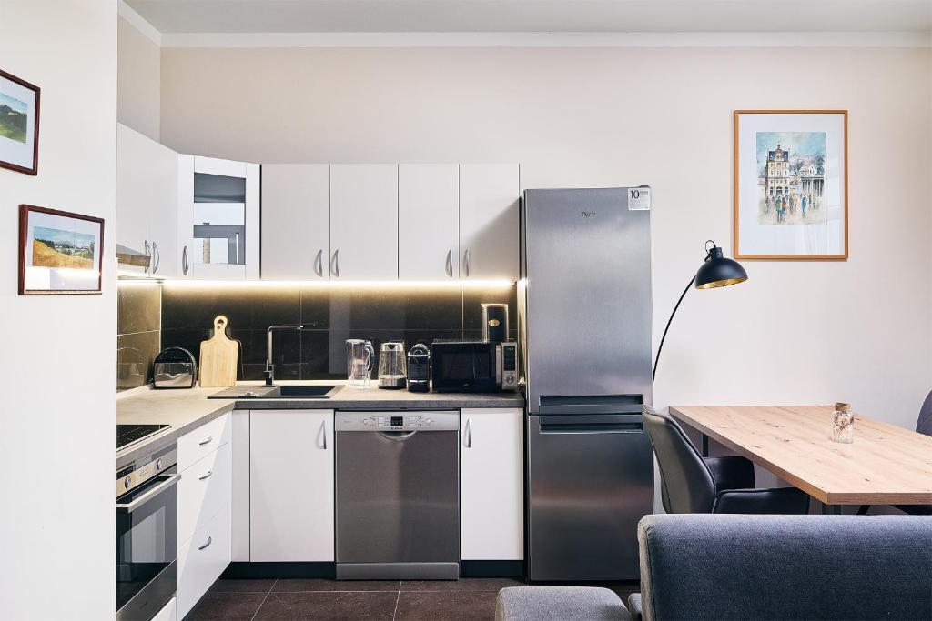 a kitchen with a stainless steel refrigerator and a table at Apartman Residence Moser 1504 in Karlovy Vary
